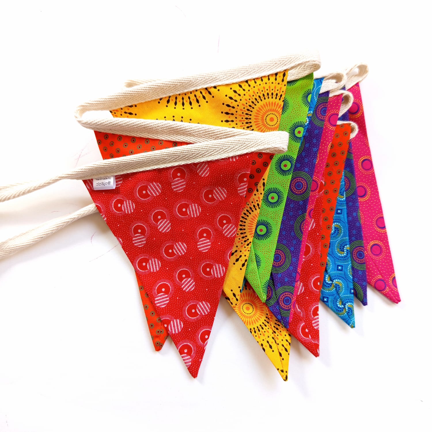 Rainbow Shweshwe bunting flags strung on a wooden hanger