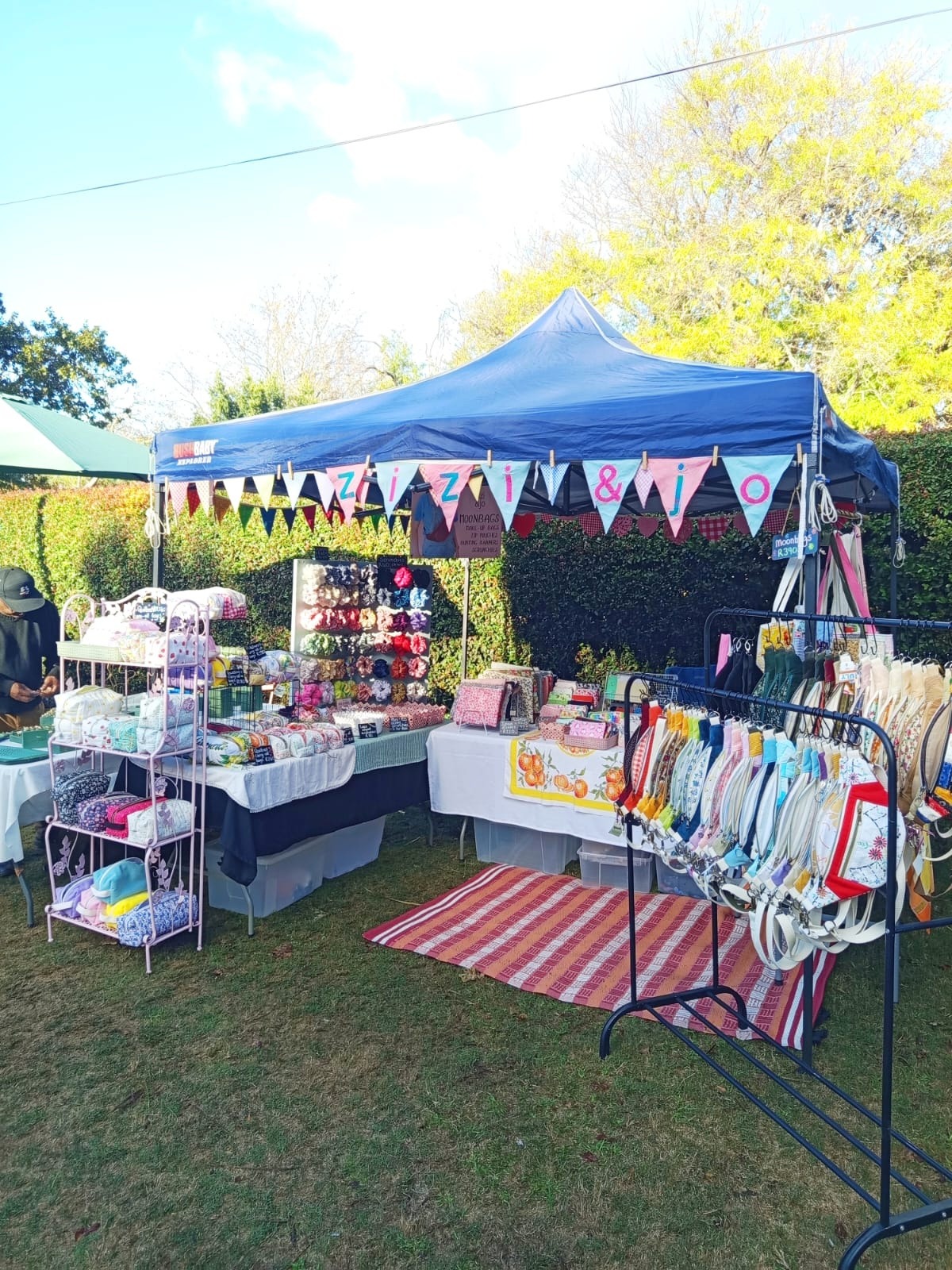 The zizi & jo market stall with rainbow bunting and handmade bags on display